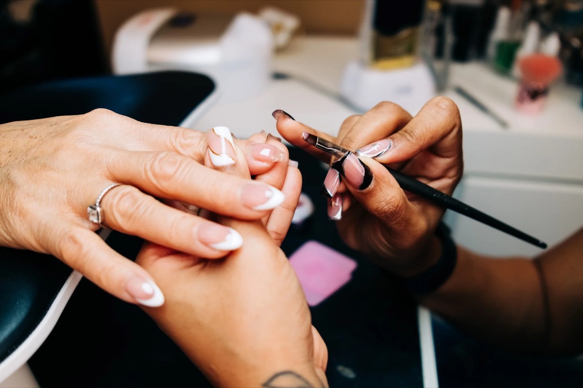 Thiara hand-painting nail art during a manicure at TLC Nails and Esthetics in Nottingham, MD